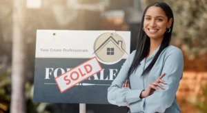 real estate agent in front of sold home sign